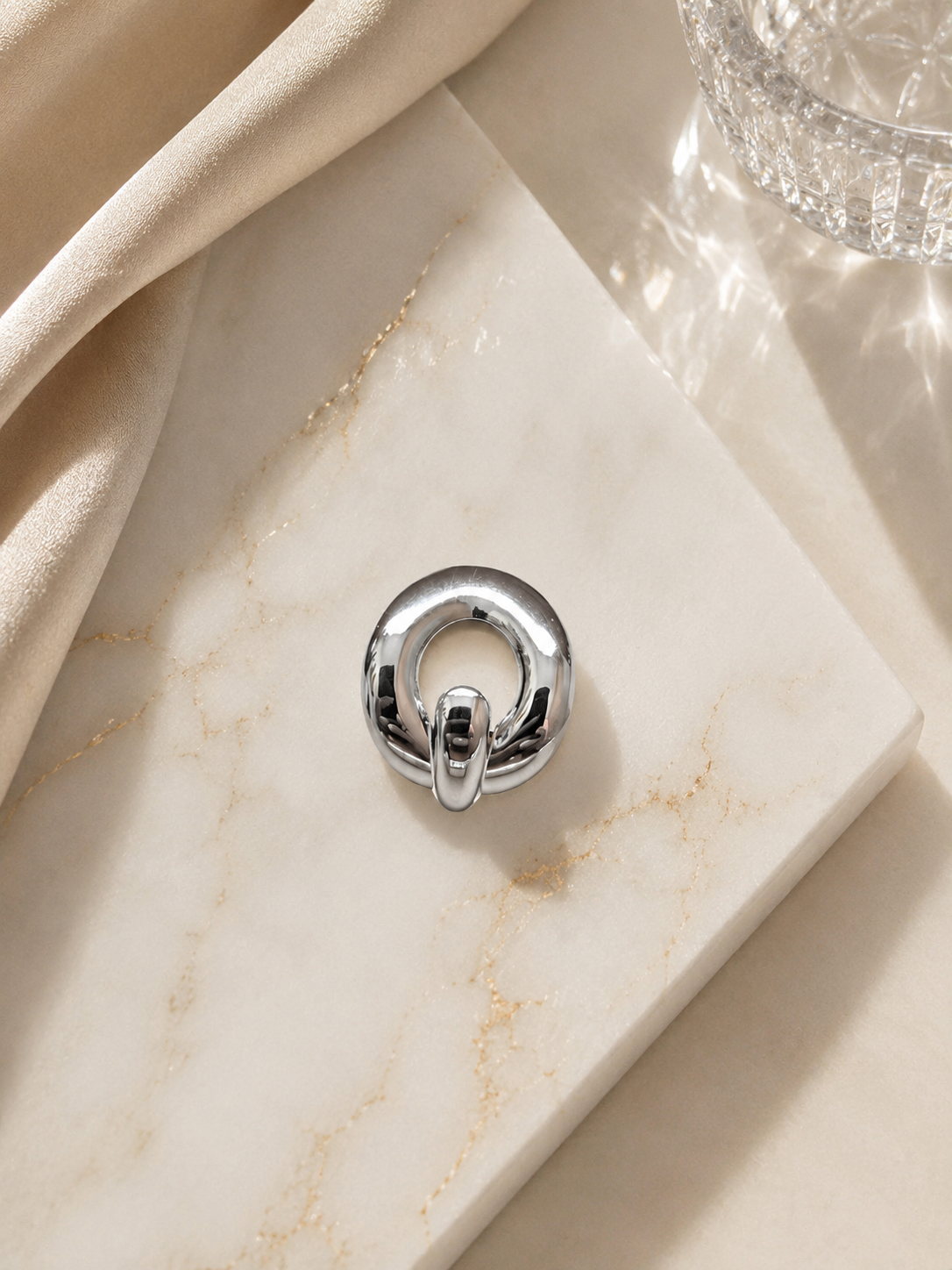 Bague argentée boucle entrelacée - photo flat lay